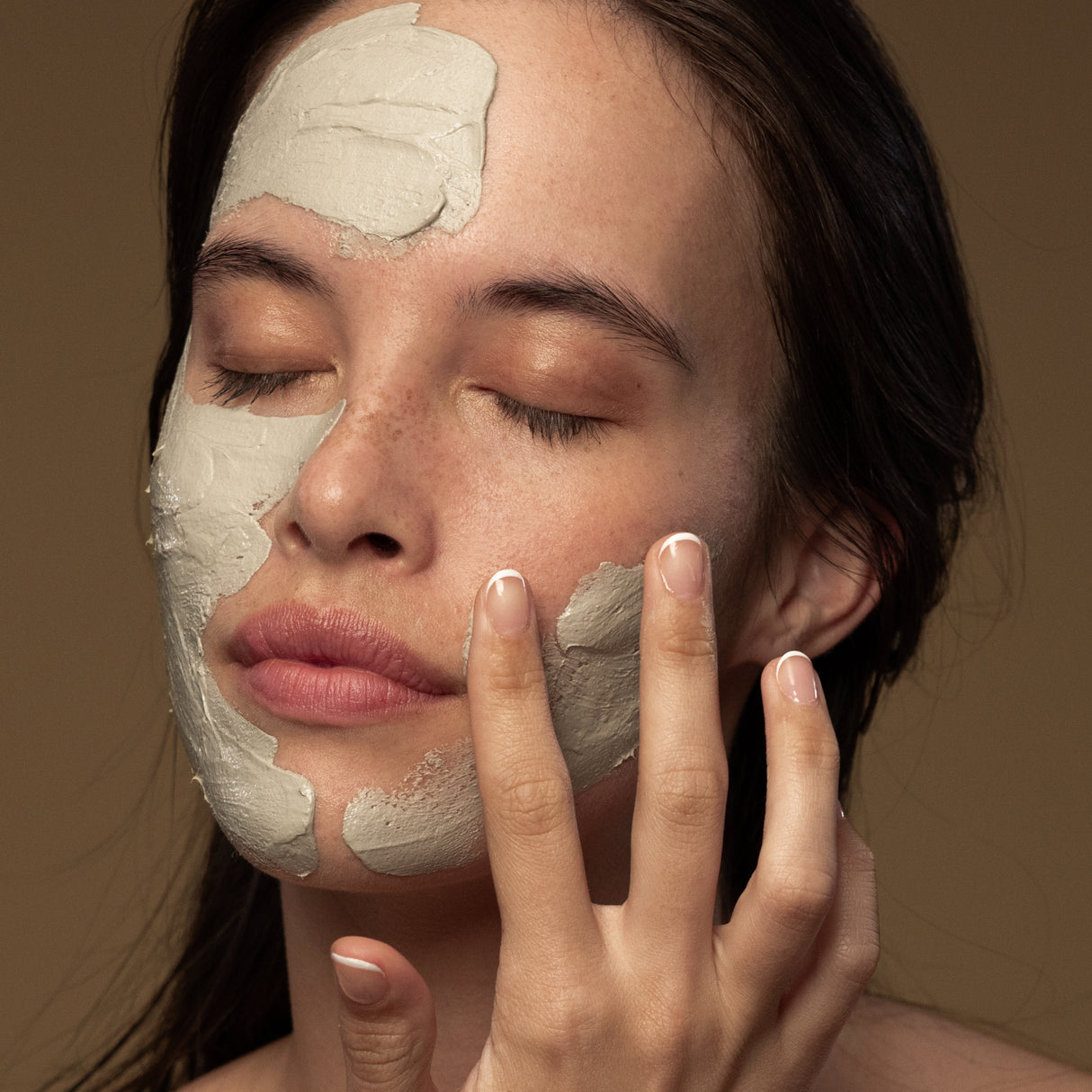 Model applying Antipodes Halo Skin Brightening Facial Mud Mask on face