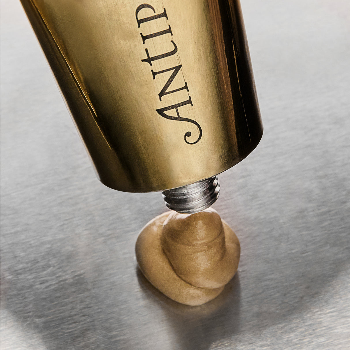 Antipodes Aura Gold Manuka Honey Radiance Mask being dispensed from tube showing texture