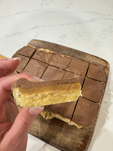 Healthy vegan caramel slice with almond base, peanut butter caramel and dark chocolate top