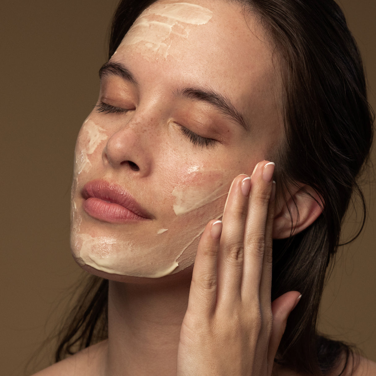 Model applying Antipodes Manuka honey face mask on skin