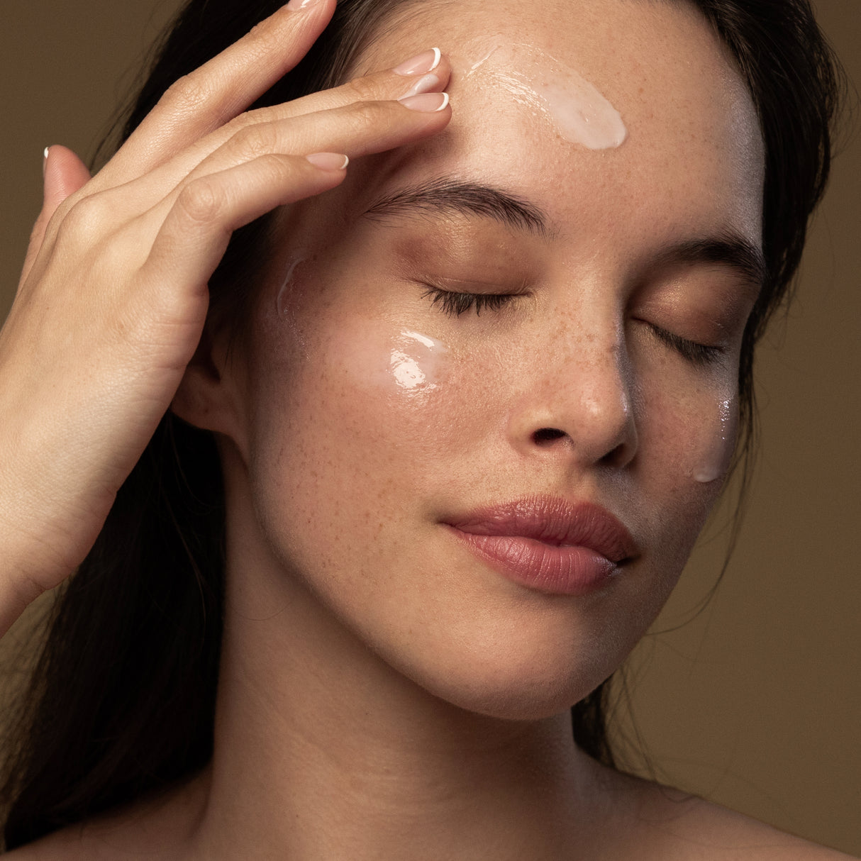 Model applying Antipodes probiotic night cream on face