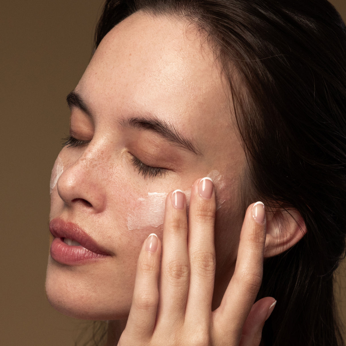 Model applying Antipodes Lime Caviar Collagen Rich Firming Cream on face