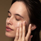 Model applying Antipodes Lime Caviar Collagen Rich Firming Cream on face