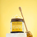 Barefoot Skincare Milk & Honey Tallow Balm open jar with honey dipper on soft yellow background