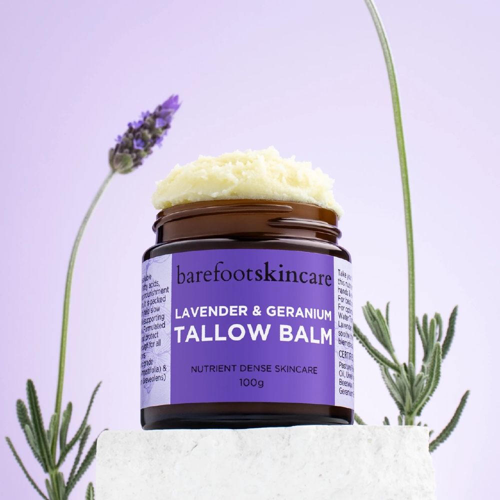 Barefoot Skincare Lavender & Geranium Tallow Balm open jar with balm texture beside lavender flowers
