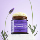 Barefoot Skincare Lavender & Geranium Tallow Balm open jar with balm texture beside lavender flowers